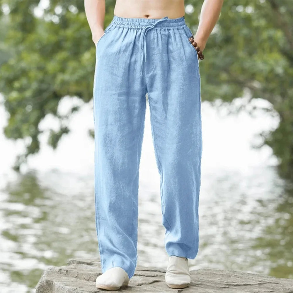 A person is wearing light blue men's cotton linen casual jogger pants outdoors.