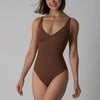 En kvinne modellerer en brun sømløs magekontroll-bodystocking.