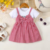 A red and white plaid cotton knit dress for girls with a bow detail, displayed on a light background.