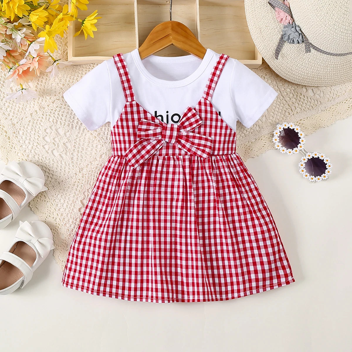 A red and white plaid cotton knit dress for girls with a bow detail, displayed on a light background.