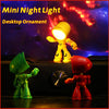 A yellow cartoon hero police night light illuminates a desk ornament next to a red toy.