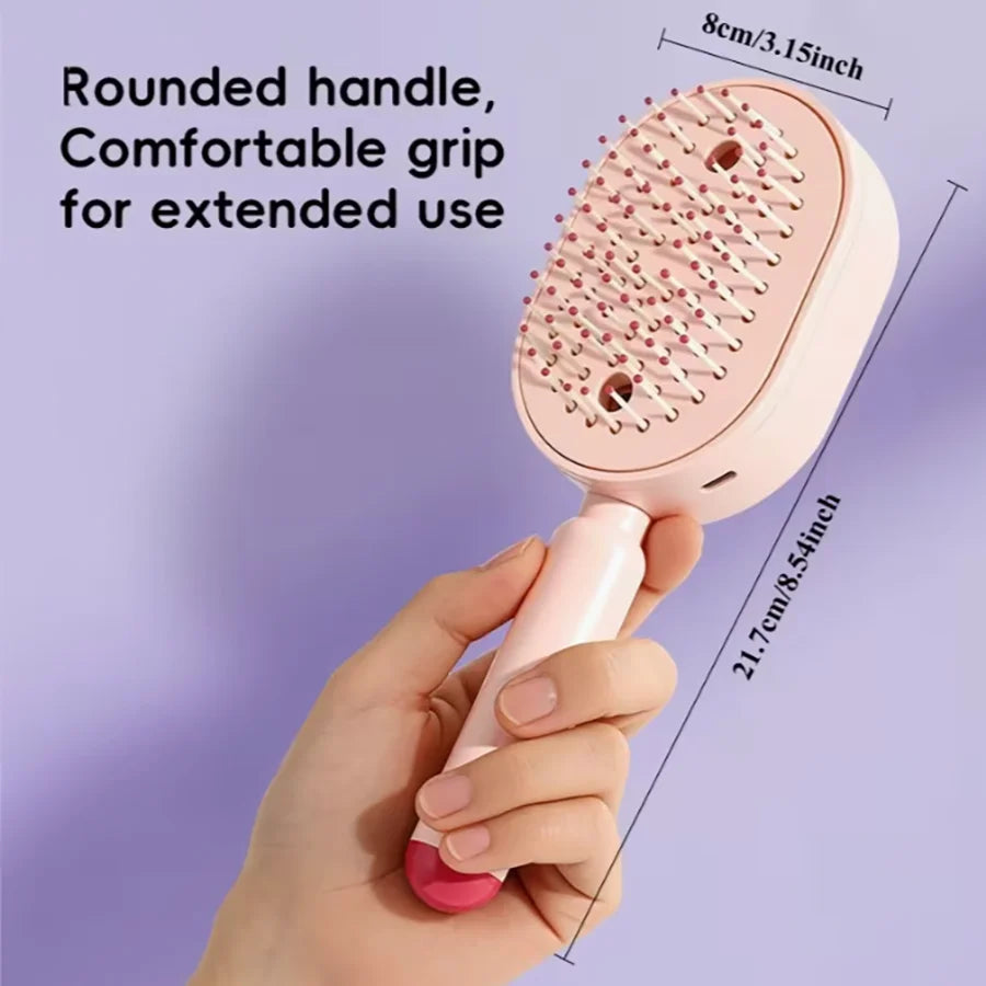 A hand holds a pink ionic steam hair brush with a rounded handle and hydrating bristles against a purple background.