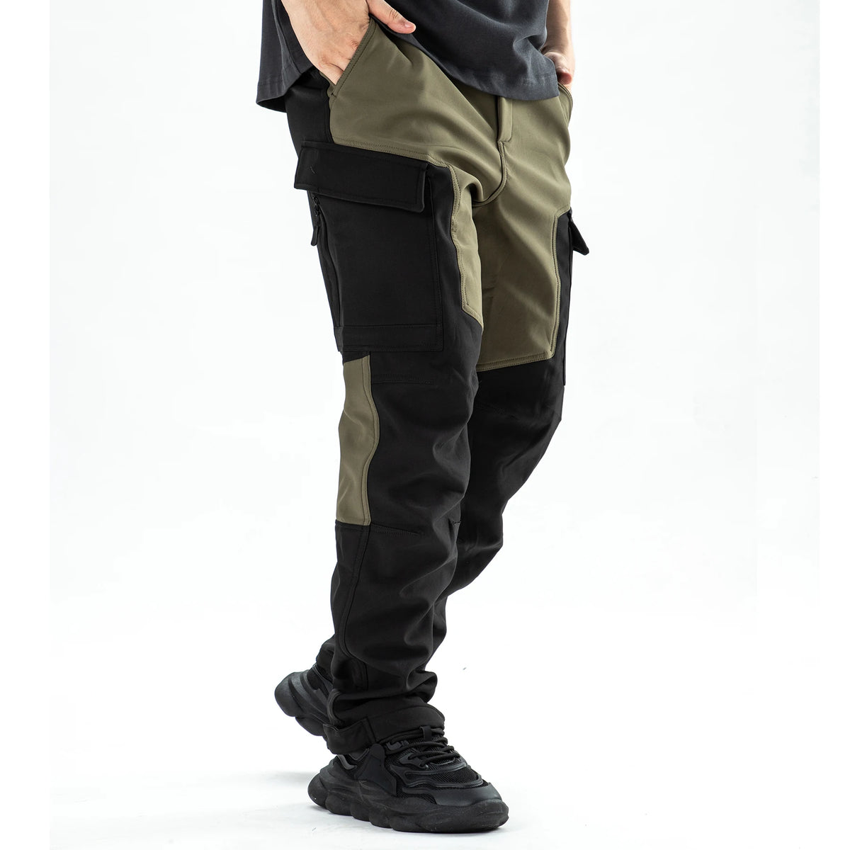 Men's waterproof insulated fleece pants in olive green and black fabric shown on a person's leg.