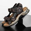A pair of brown leather air cushion sandals with black straps resting on a dark surface.