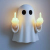 A white ghost-shaped lamp illuminates glowing fingers making a sassy gesture on a wall.