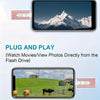 A mobile phone displaying a scenic mountain view, next to a pink adapter and a flash drive.