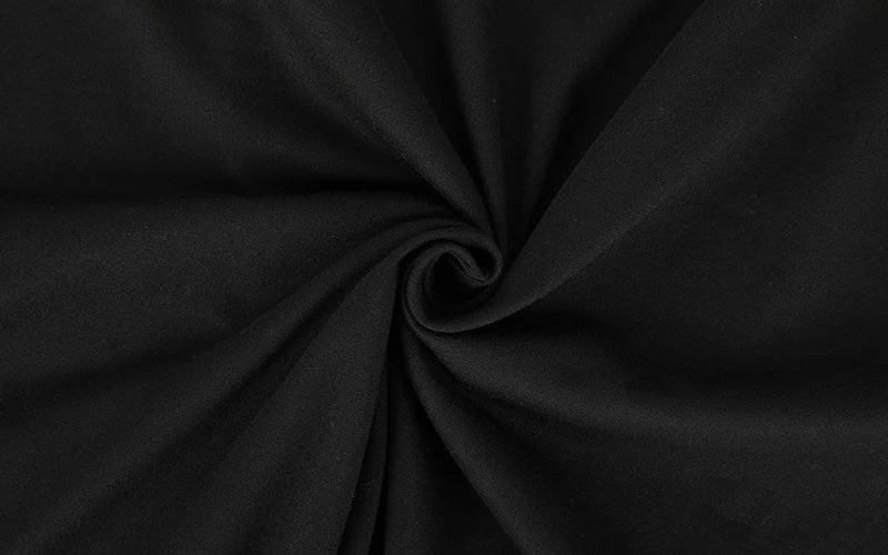 A dark gray or black fabric is tightly rolled into a ball.