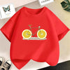 A bright red kids t-shirt featuring a graphic print of a bicycle with sliced oranges on the front.