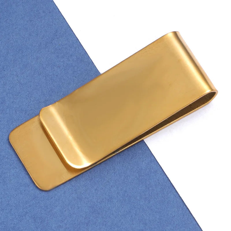 A gold metal tie clip lying on a blue-gray felt background.