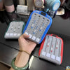 A hand holds a blue light-up rhythm game machine for kids next to other similar devices.