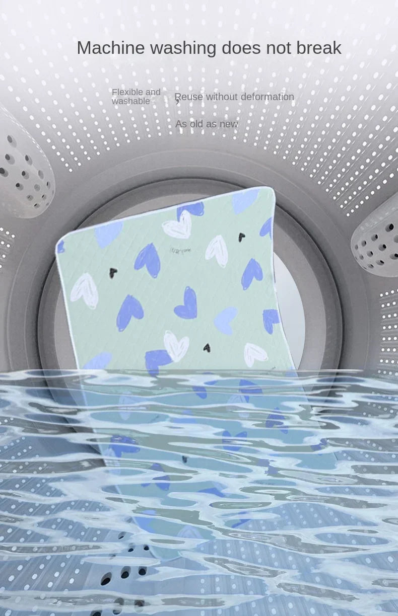 A light blue waterproof baby mattress protector with a cute cartoon design floating in water.