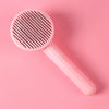 A pink self-cleaning pet grooming comb with fine teeth is shown against a solid pink background.