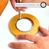 Hands are using a silver pen to draw on a yellow stainless steel round flower circle compass ruler.
