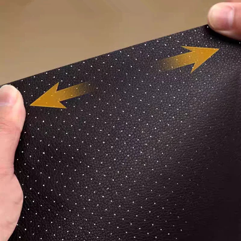 A hand is applying a self-adhesive PU leather repair patch to a dark brown perforated leather surface.