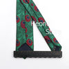 Primer plano de una corbata slim fit de jacquard para hombre con patrón verde y detalles en rojo.