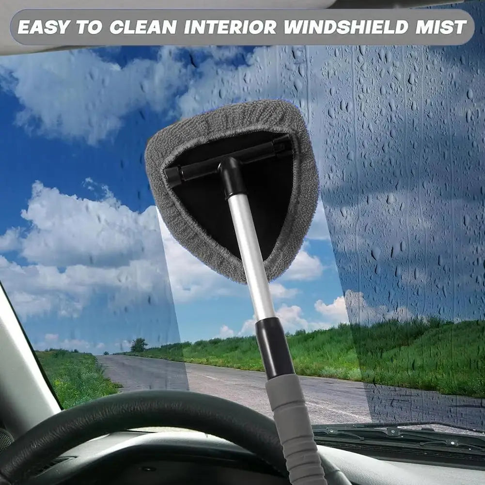 A telescopic windshield cleaning brush with a gray microfiber pad is shown against a rainy outdoor background.