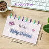 A pink marble-patterned planner or binder titled 52 Weeks Savings Challenge lying on a wooden surface next to a laptop keyboa