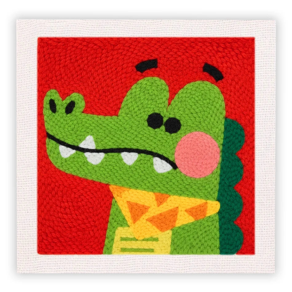 Bordado de fieltro rojo con cara de dragón verde, ojos negros y detalles rosados.