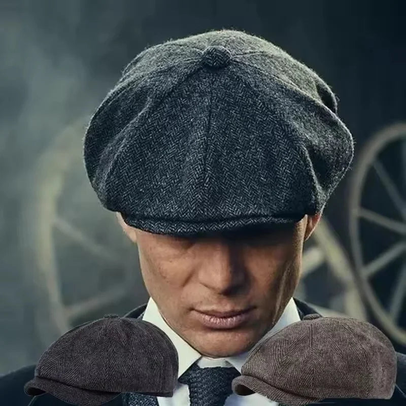 A close-up of a man wearing a dark gray newsboy cap and tweed jacket with matching fabric ear coverings.
