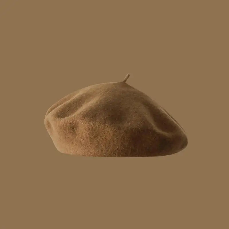 A close-up view of a classic wool beret hat in a warm brown color.