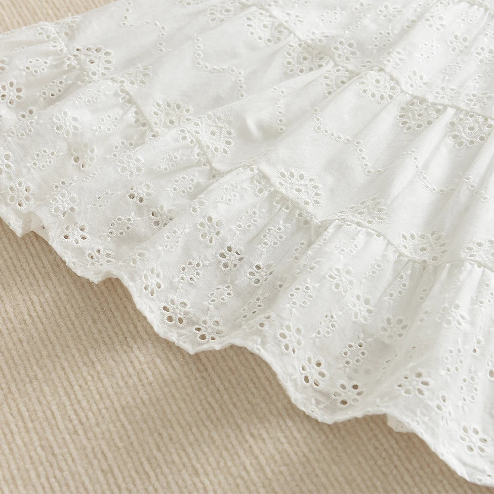 White cotton dress with delicate eyelet lace trim and ruffled tiers for a toddler girl