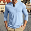 A man wearing a light blue long-sleeve casual shirt with a chest pocket and khaki pants.