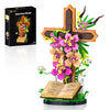 A Jesus Cross Flower building set featuring a wooden cross adorned with pink and yellow flowers and greenery.