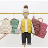 A mannequin displays a yellow quilted vest on a hanger, with other colored vests visible in the background.