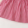 A close-up of a red and white gingham cotton knit dress with a bow accent.
