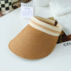 A woven straw sun hat with a light beige brim resting on a white surface.