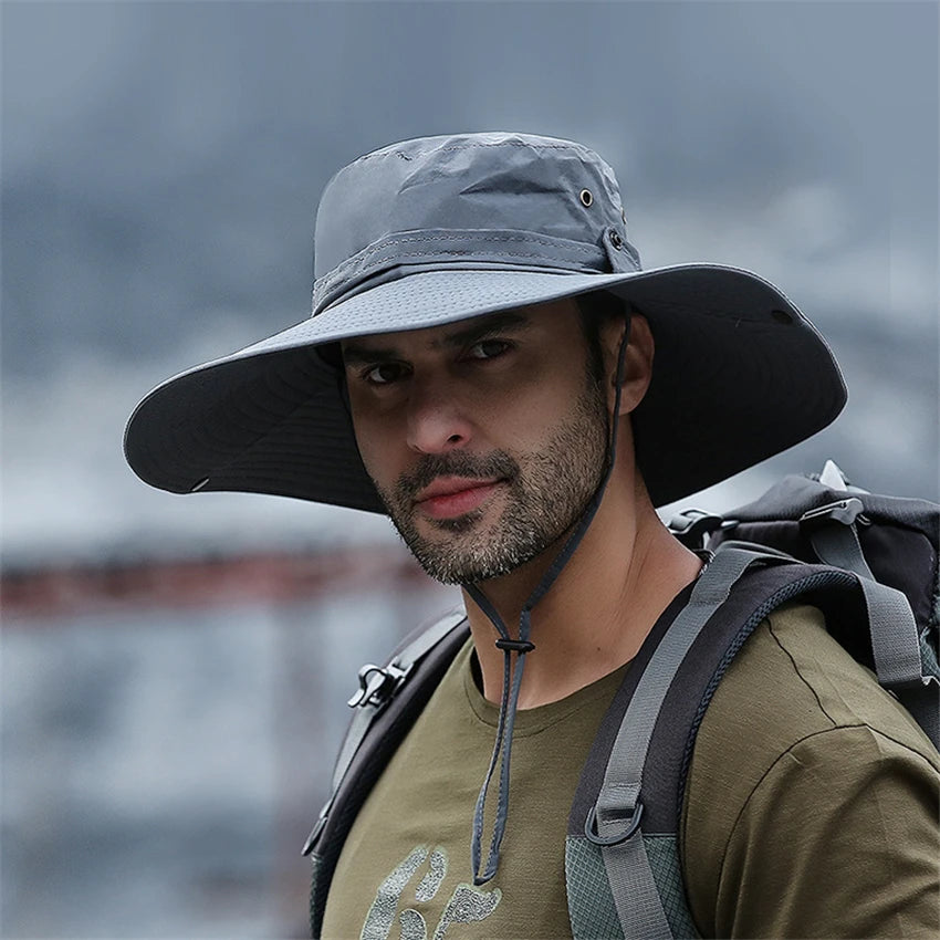 A man wearing a gray wide brim mesh bucket hat and a green shirt, looking directly at the camera.