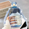 Eine Hand hält eine klare blaue Wasserflasche mit verstellbarem Riemen, die verschiedene Volumenmarkierungen zeigt.