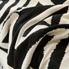 Nahaufnahme eines schwarz-weißen Zebrastreifen-Chenille-Sofastoffs in weichen Falten.