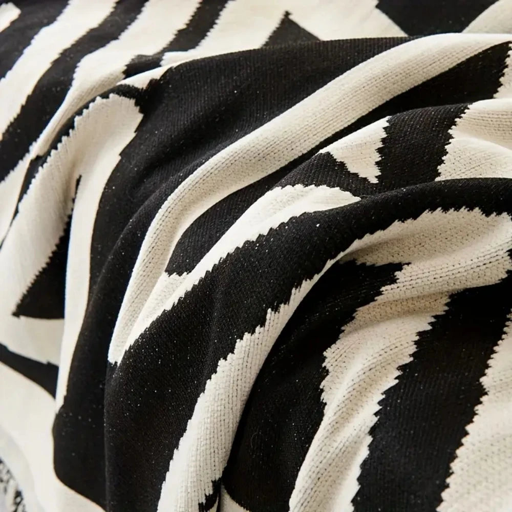Nahaufnahme eines schwarz-weißen Zebrastreifen-Chenille-Sofastoffs in weichen Falten.