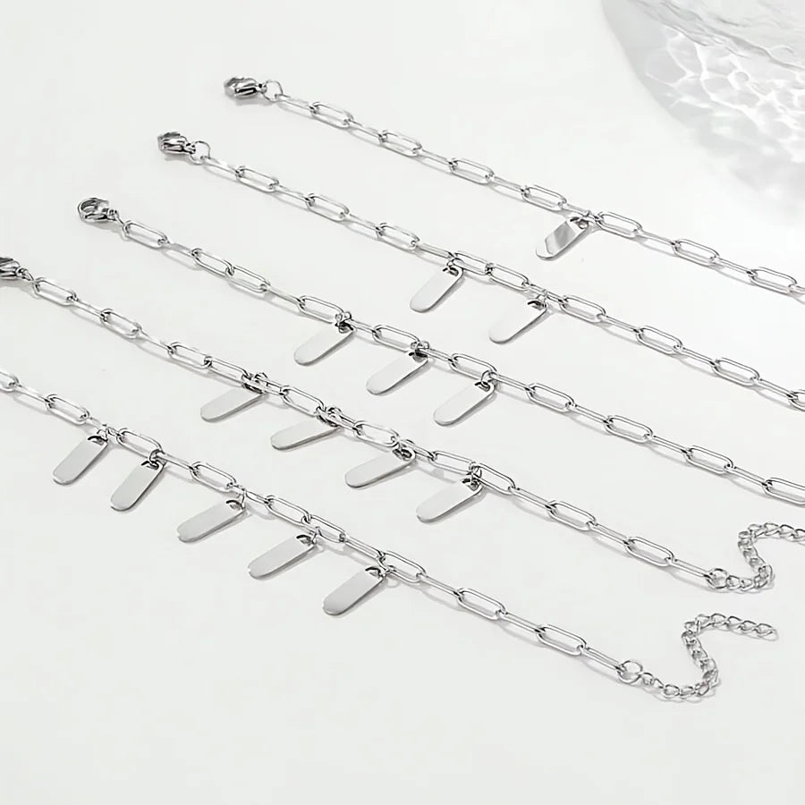 Varios brazaletes personalizados de acero inoxidable bañado en oro con cadenas ajustables sobre fondo blanco