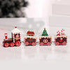 A set of miniature red and white Santa Claus Christmas train decorations with festive greenery and gifts.