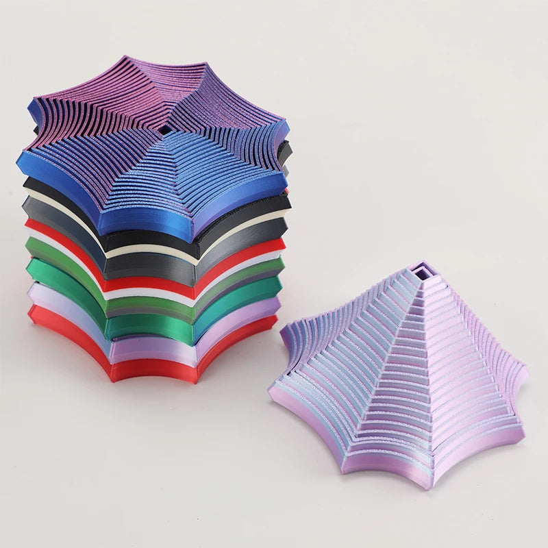 En stabel med geometriske fidget-leker i nyanser av blått, lilla, grønt og rødt.