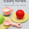 A set of pretend play kitchen sink components including a pink cup, a red apple, and small white beads on yellow plates.