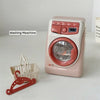 A pink pretend play kitchen set featuring a washing machine, coffee maker, water dispenser, and toaster.