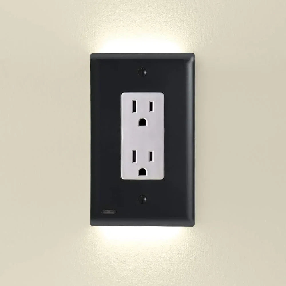 Schwarze Abdeckung einer Duplex-Steckdose mit integriertem, automatisch schaltendem LED-Nachtlicht an der Wand.