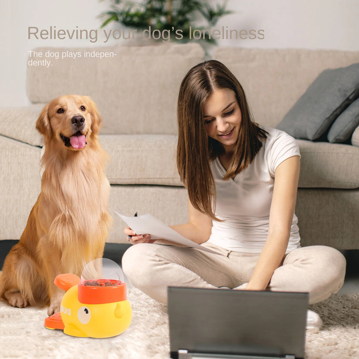 Mujer interactúa con un juguete interactivo para perros que dispensa golosinas mientras un golden retriever espera cerca.