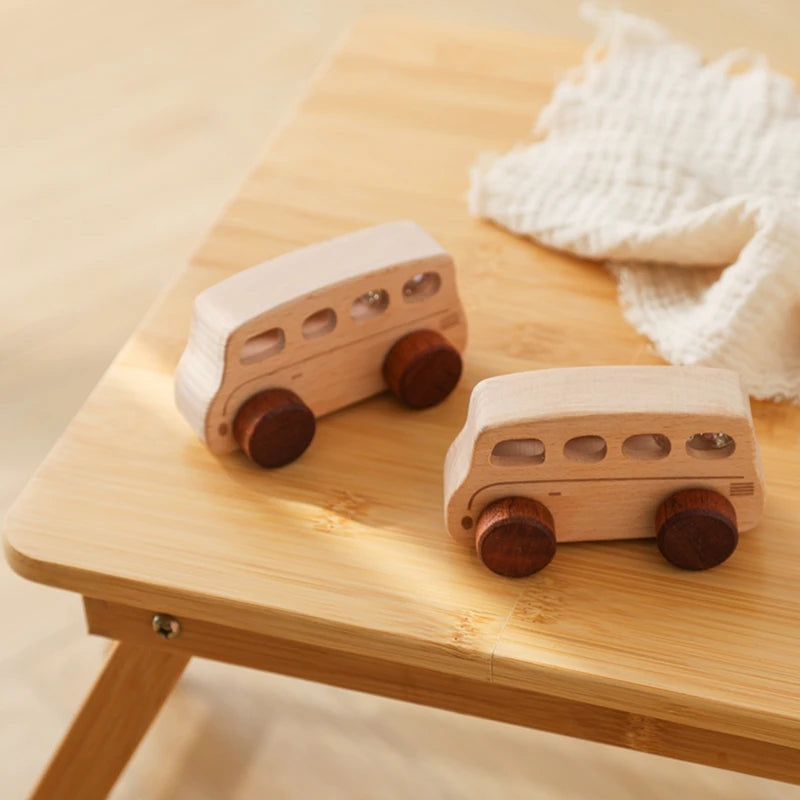 A light wooden hand-pushed cart toy for toddlers resting on a wooden table next to a white cloth.