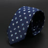 Corbata azul oscuro con lunares y rayas blancas, enrollada.