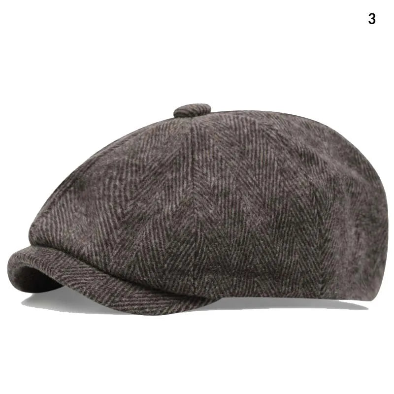A dark gray vintage newsboy cap with a folded brim shown from the side.
