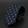 Corbata azul oscura con diseño floral blanco sutil, doblada y exhibida sobre fondo oscuro.