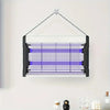 A black electric mosquito killer lamp with a UV light trap suspended by a wire against a white wall.