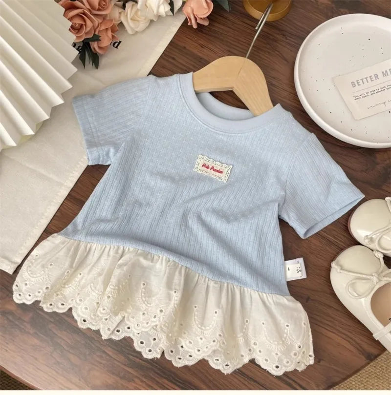 Light blue girls cotton short sleeve tee with a lace hem and a small embroidered tag displayed on a wooden hanger.