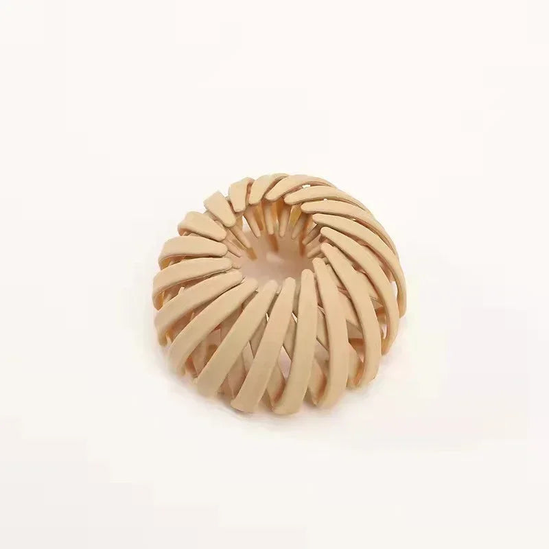 Et beige fuglerede-hårspenne designet for hestehaler