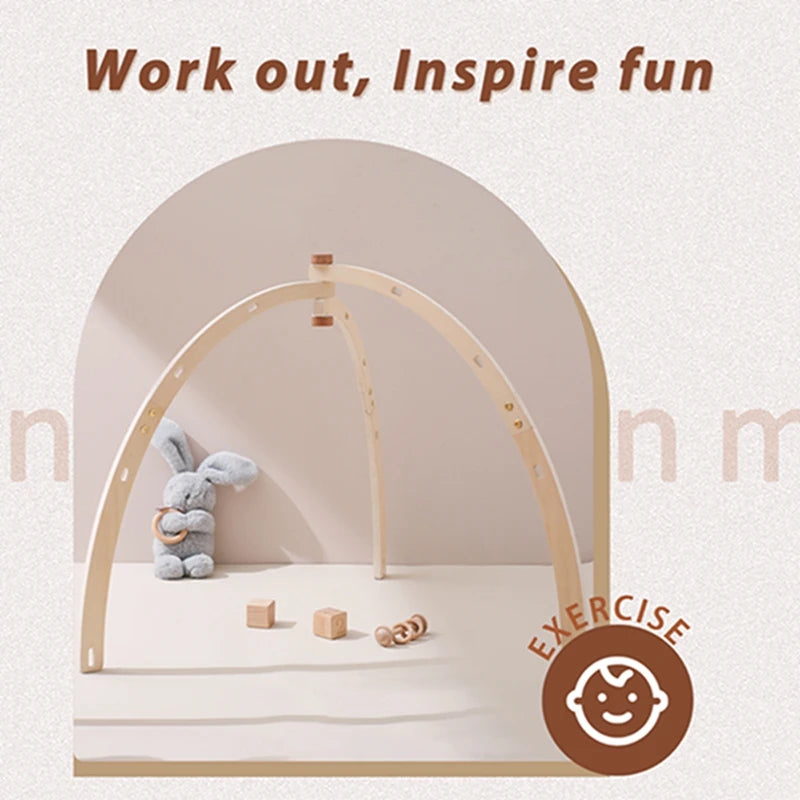 A natural wooden baby play gym arch with a stuffed toy and small wooden blocks.
