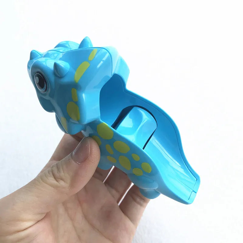 A hand holds a bright blue marble run building block piece with yellow dots.